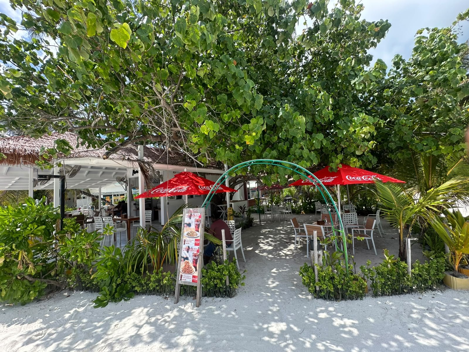 The entrance today, with a metal arch and red signage beside the path
