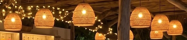 A woven pendant lamp glowing warm